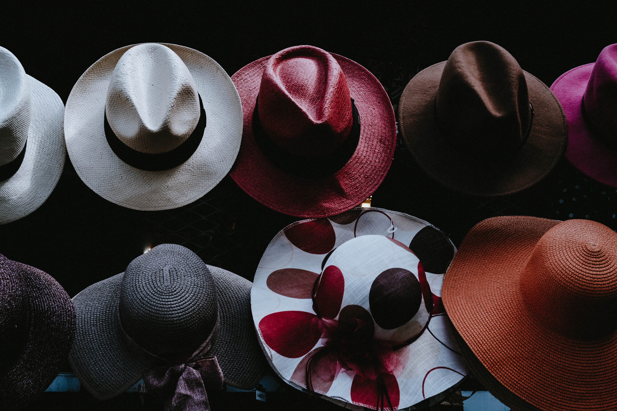 A photo of cowboy hats of multiple colors and designs